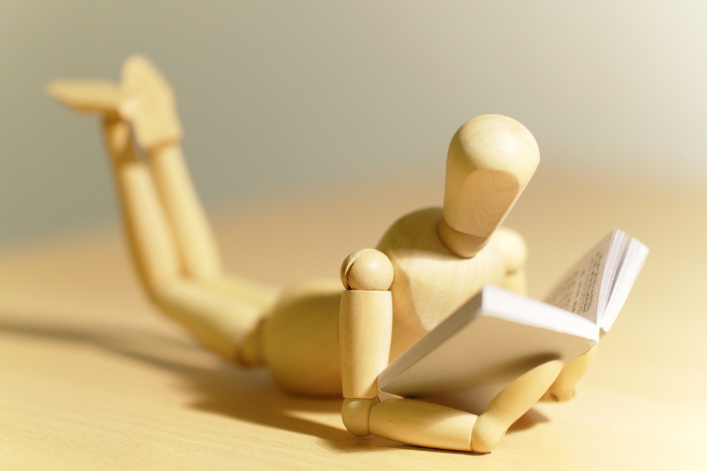 Wooden figurine reading a book