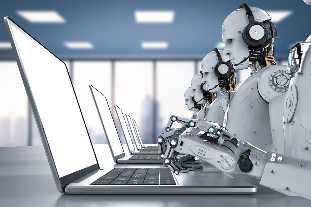 A group of robots sitting in front of laptops